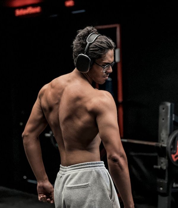 Man performing a focused strength exercise in a dark room.